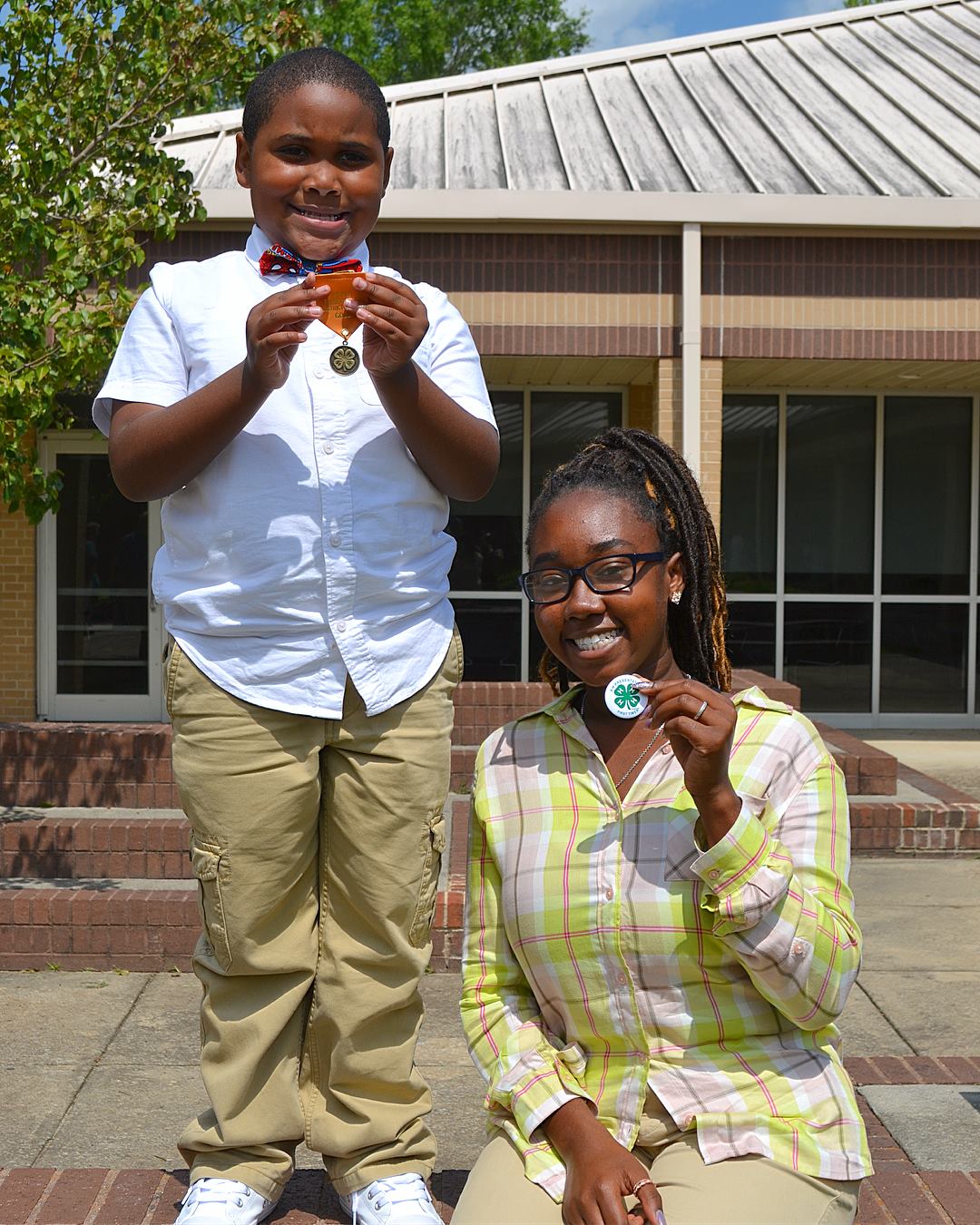 Two youth holding medals from presentation