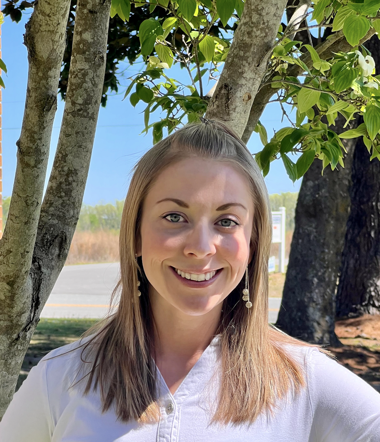 Portrait of a woman standing in front of a tree.