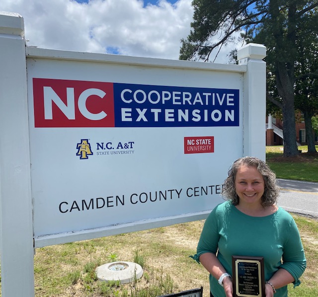 A woman poses in front of the Camden County Center sign.